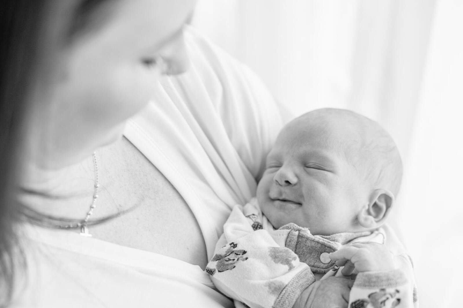 mother nuzzles newborn baby in her arms